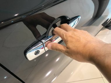 Adamın eli arabanın arka kapısını açıyor.