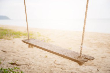 Sahilde ahşap salıncak ve kum arka planı