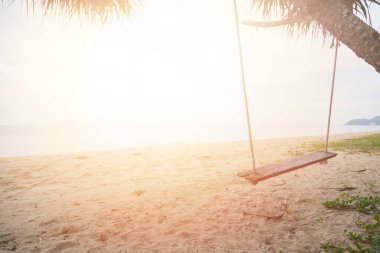 Sahilde ahşap salıncak ve kum arka planı