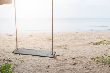 Sahilde ahşap salıncak ve kum arka planı