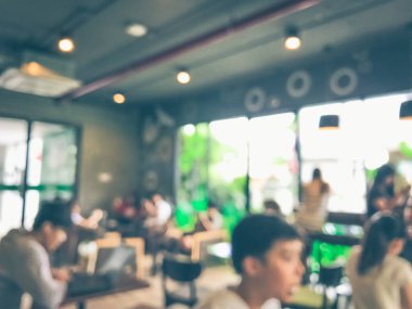 Kafede arka planda bir sürü müşterinin bulanık görüntüsü.