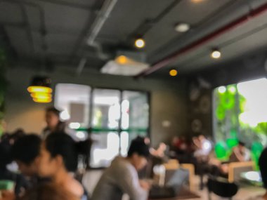 Kafede arka planda bir sürü müşterinin bulanık görüntüsü.