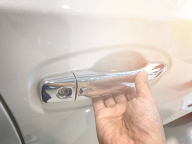 Adamın eli arabanın arka kapısını açıyor.