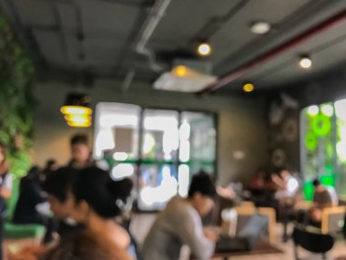 Kafede arka planda bir sürü müşterinin bulanık görüntüsü.