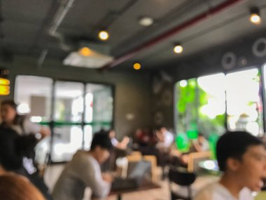 Kafede arka planda bir sürü müşterinin bulanık görüntüsü.