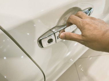 Adamın eli arabanın arka kapısını açıyor.