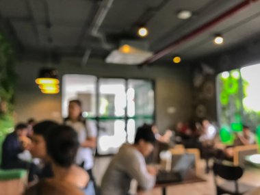 Kafede arka planda bir sürü müşterinin bulanık görüntüsü.