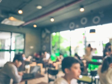 Kafede arka planda bir sürü müşterinin bulanık görüntüsü.