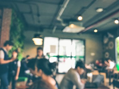 Kafede arka planda bir sürü müşterinin bulanık görüntüsü.