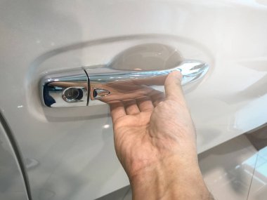 Adamın eli arabanın arka kapısını açıyor.