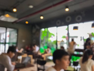 Kafede arka planda bir sürü müşterinin bulanık görüntüsü.