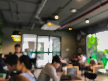 Kafede arka planda bir sürü müşterinin bulanık görüntüsü.