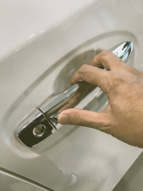 Adamın eli arabanın arka kapısını açıyor.