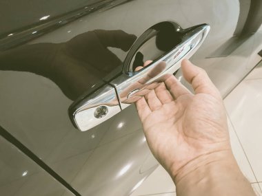 Adamın eli arabanın arka kapısını açıyor.