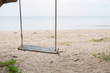 Sahilde ahşap salıncak ve kum arka planı