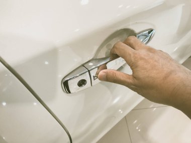 Adamın eli arabanın arka kapısını açıyor.