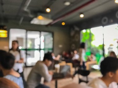 Kafede arka planda bir sürü müşterinin bulanık görüntüsü.