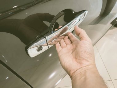 Adamın eli arabanın arka kapısını açıyor.