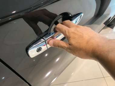 Adamın eli arabanın arka kapısını açıyor.