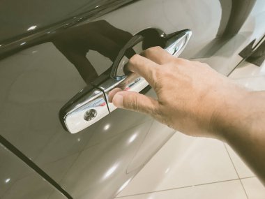 Adamın eli arabanın arka kapısını açıyor.