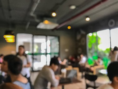 Kafede arka planda bir sürü müşterinin bulanık görüntüsü.