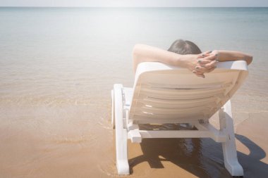 Tropikal plajda tatil. Plaj yatağında dinlenen temiz okyanus suyuyla birlikte.