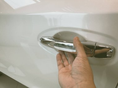 Adamın eli arabanın arka kapısını açıyor.