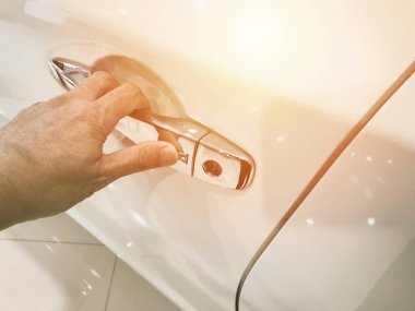 Adamın eli arabanın arka kapısını açıyor.