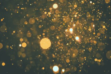 Soyut bulanık altın sarısı, siyah arkaplanlı parıltı bokeh