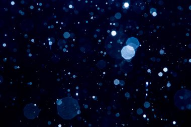 Siyah arkaplan ile soyut bulanık mavi parlayan bokeh