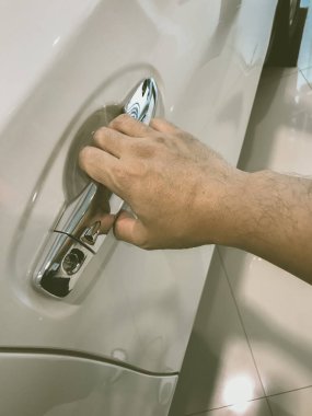 Adamın eli arabanın arka kapısını açıyor.