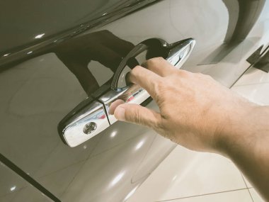 Adamın eli arabanın arka kapısını açıyor.