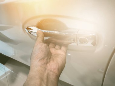 Adamın eli arabanın arka kapısını açıyor.