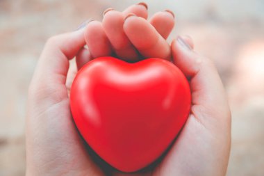 Kadın arka plan için kırmızı kalp kullanım tutun