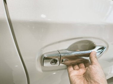 Adamın eli arabanın arka kapısını açıyor.