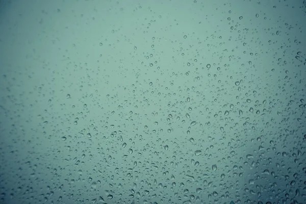 Pencere camındaki su damlası, siyah zemin.