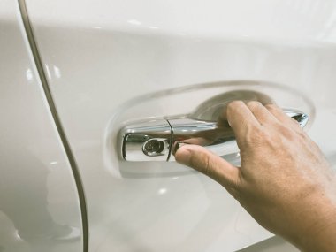 Adamın eli arabanın arka kapısını açıyor.