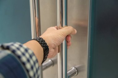 Elle açılan metal, modern ofis kapısı.