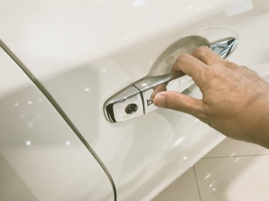 Adamın eli arabanın arka kapısını açıyor.