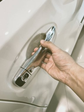 Adamın eli arabanın arka kapısını açıyor.