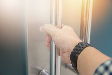 Elle açılan metal, modern ofis kapısı.