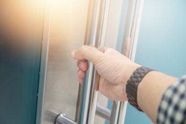 Elle açılan metal, modern ofis kapısı.