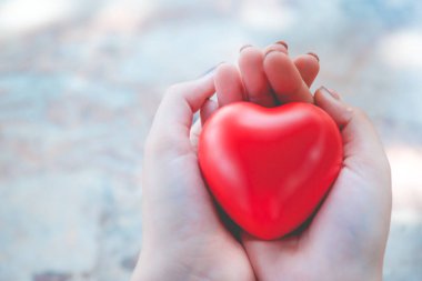 Kadın arka plan için kırmızı kalp kullanım tutun