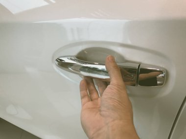 Adamın eli arabanın arka kapısını açıyor.