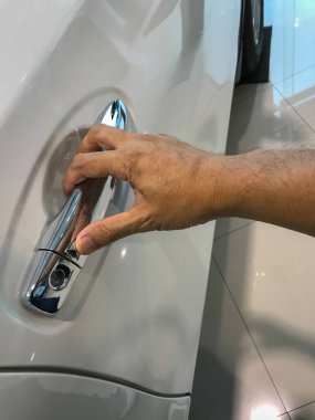 Adamın eli arabanın arka kapısını açıyor.