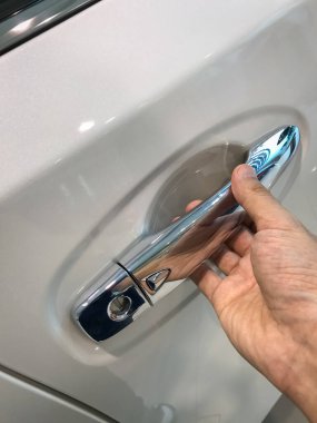 Adamın eli arabanın arka kapısını açıyor.