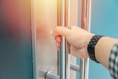 Elle açılan metal, modern ofis kapısı.