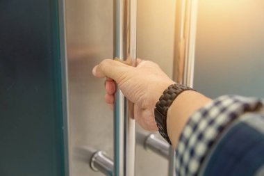 Elle açılan metal, modern ofis kapısı.