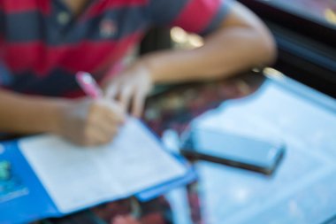 Masa arkasında kamera ve akıllı telefon ile uygulamayı dolduran adamın bulanık görüntüsü