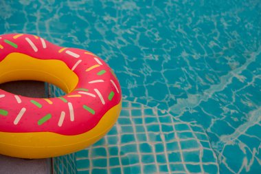 Mavi yüzme havuzu arka planında lastik halka